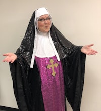 a woman dressed as a nun with her hands outstretched