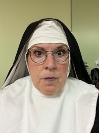 a woman in a nun costume is posing for a photo